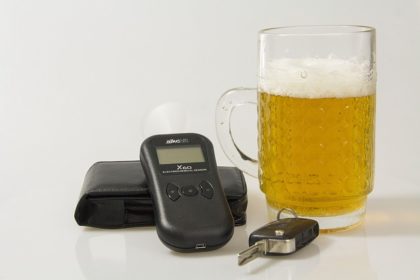Breathalyzer next to car keys and beer