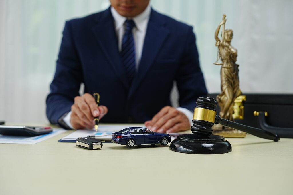 Car Accident Attorney in his office with judge's gavel and toy car on the table