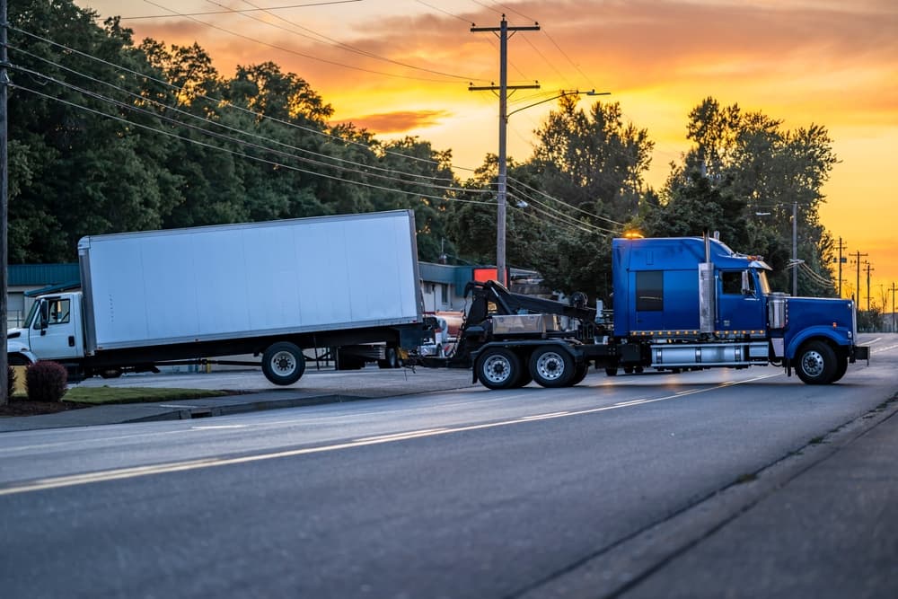 Mobile blue roadside assistance powerful tow big rig semi truck tractor towing broken after accident