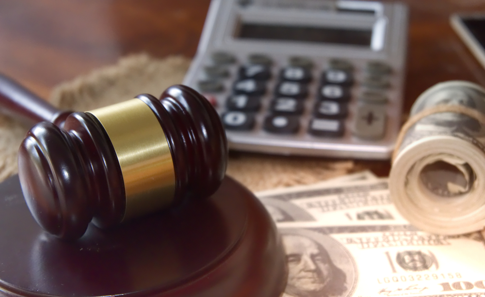 Gavel, calculator, and money illustrating the calculation of damages and compensation in wrongful death cases.